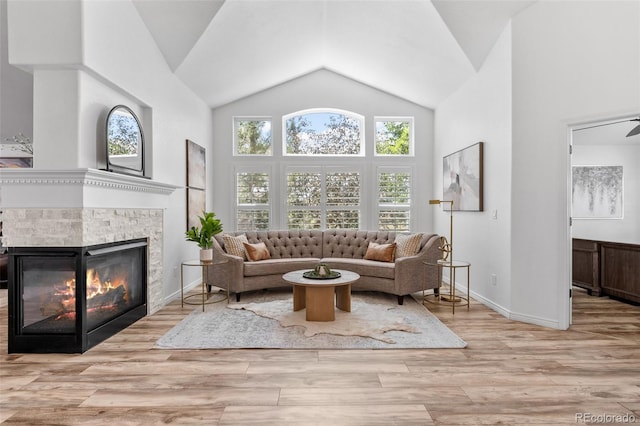 9576 E 147th Pl, Brighton, CO 80602 - living room featuring a glass covered fireplace, high vaulted ceiling, and wood finished floors