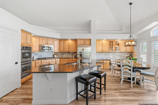 9576 E 147th Pl, Brighton, CO 80602 - kitchen with stainless steel appliances, dark countertops, a chandelier, glass insert cabinets, and a breakfast bar
