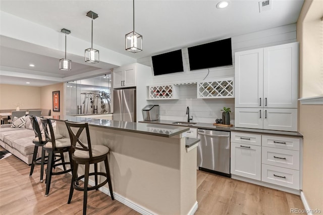 9576 E 147th Pl, Brighton, CO 80602 - kitchen with appliances with stainless steel finishes, open floor plan, light wood finished floors, dark countertops, and recessed lighting
