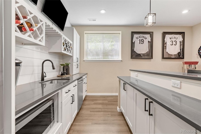 9576 E 147th Pl, Brighton, CO 80602 - kitchen featuring dark countertops, appliances with stainless steel finishes, white cabinetry, light wood-style flooring, and recessed lighting