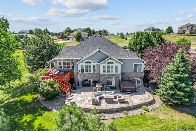 9576 E 147th Pl, Brighton, CO 80602 - rear view of property with a deck, a patio, an outdoor living space with a fire pit, stone siding, and a hot tub