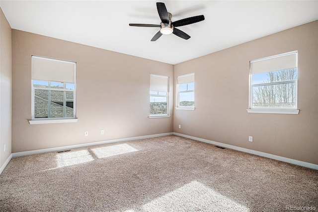 carpeted empty room with ceiling fan and a healthy amount of sunlight