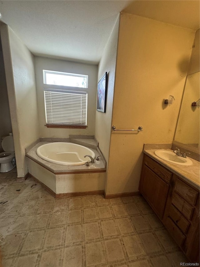 bathroom with a tub to relax in, vanity, and toilet