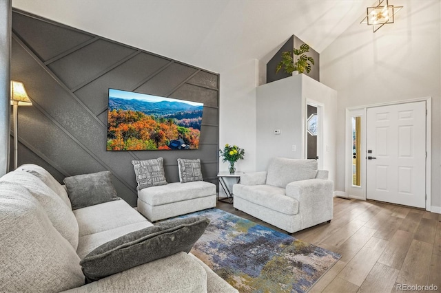 living room with wood-type flooring and high vaulted ceiling