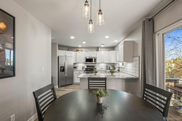 dining space featuring sink and light hardwood / wood-style flooring