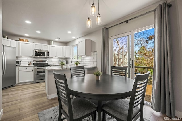 dining room featuring sink and light hardwood / wood-style floors