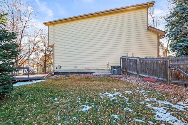 view of property exterior featuring a deck, central AC unit, and a lawn