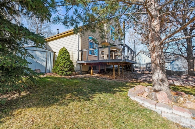 back of house featuring a storage shed, a lawn, and a deck