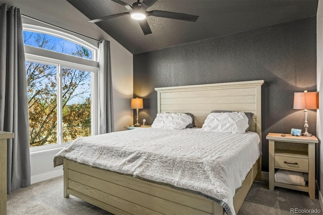 carpeted bedroom featuring multiple windows, lofted ceiling, and ceiling fan