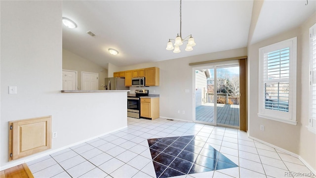 kitchen with hanging light fixtures, a chandelier, vaulted ceiling, light tile patterned floors, and appliances with stainless steel finishes