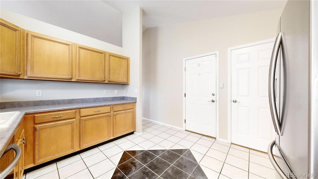 kitchen featuring dishwasher, sink, stainless steel fridge, vaulted ceiling, and light tile patterned floors