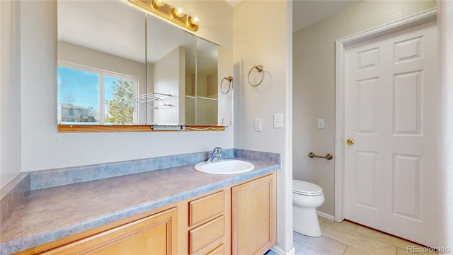 bathroom with tile patterned flooring, vanity, and toilet