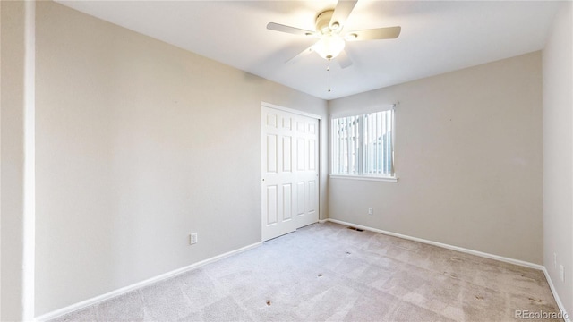 unfurnished room featuring light carpet and ceiling fan