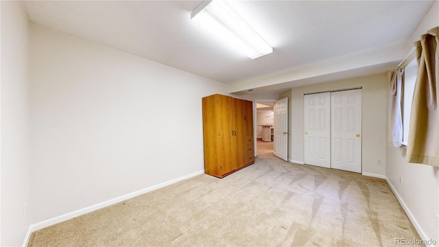 unfurnished bedroom with a closet and light colored carpet