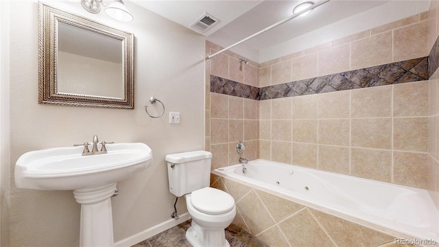 bathroom featuring tiled shower / bath combo and toilet