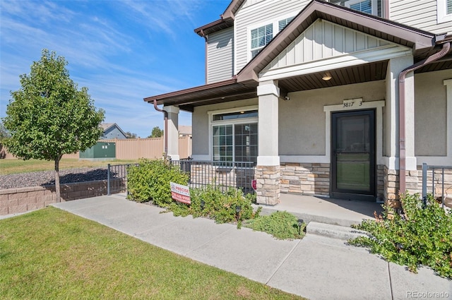 doorway to property featuring a yard and covered porch