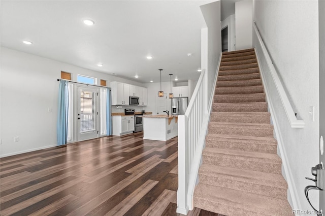 stairway featuring wood-type flooring and sink