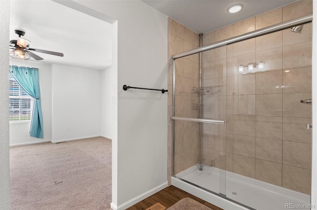 bathroom with ceiling fan, hardwood / wood-style flooring, and walk in shower