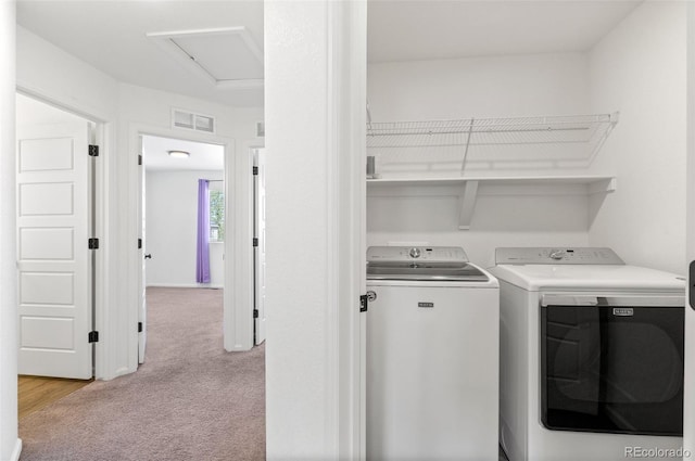 laundry room with light colored carpet and washer and dryer