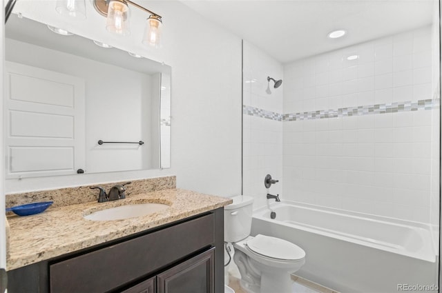 full bathroom with tiled shower / bath, vanity, and toilet