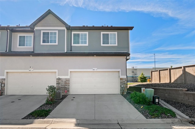 view of front of property featuring a garage and central AC