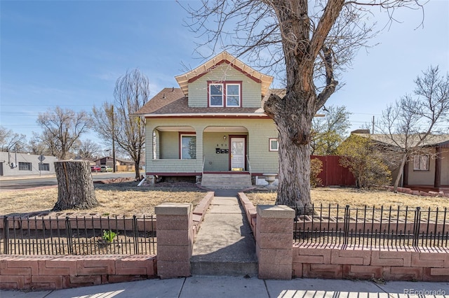 835 N Union Blvd, Colorado Springs, CO 80909 - view of front of home featuring a porch, a shingled roof, and a fenced front yard