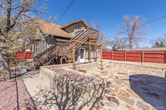 835 N Union Blvd, Colorado Springs, CO 80909 - back of property featuring stairs, a fenced backyard, a deck, a patio area, and roof with shingles