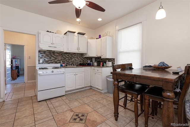 835 N Union Blvd, Colorado Springs, CO 80909 - kitchen with gas range gas stove, under cabinet range hood, white cabinets, tasteful backsplash, and a ceiling fan