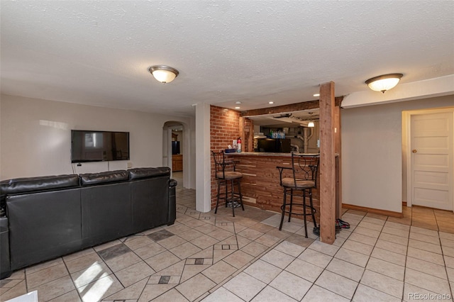 835 N Union Blvd, Colorado Springs, CO 80909 - living room with arched walkways, a dry bar, a textured ceiling, light tile patterned floors, and recessed lighting