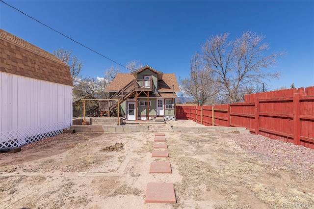 835 N Union Blvd, Colorado Springs, CO 80909 - rear view of property with a fenced backyard, stairway, an outdoor structure, a deck, and roof with shingles