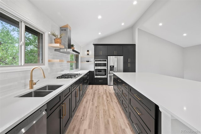 kitchen with ventilation hood, stainless steel appliances, tasteful backsplash, vaulted ceiling, and sink