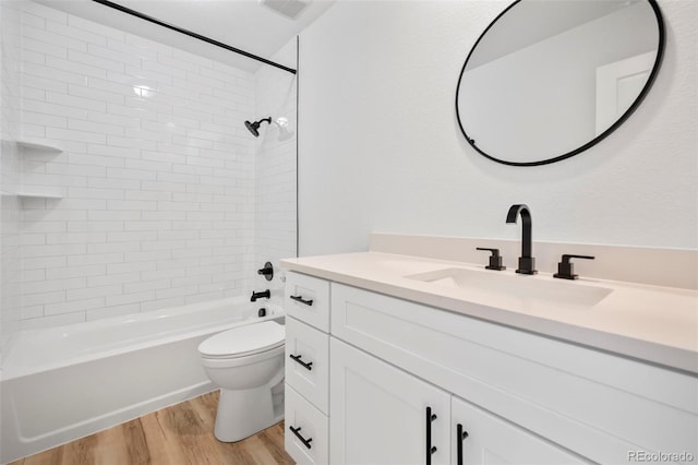 full bathroom with hardwood / wood-style flooring, toilet, vanity, and tiled shower / bath