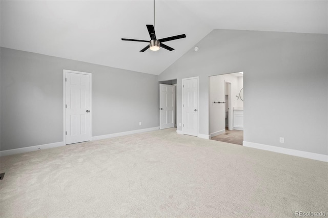 unfurnished bedroom featuring ceiling fan, light carpet, connected bathroom, and high vaulted ceiling