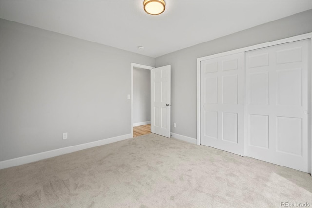 unfurnished bedroom featuring light colored carpet and a closet