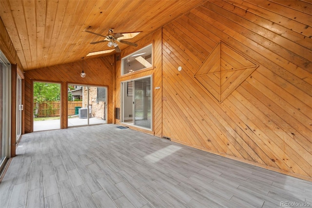 interior space with ceiling fan, lofted ceiling with skylight, and wooden ceiling