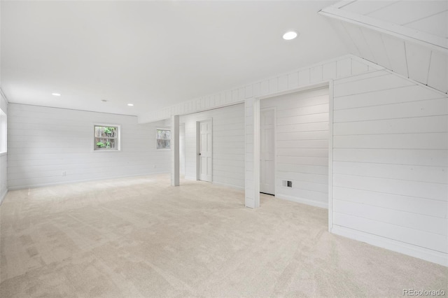 interior space featuring light carpet and wood walls