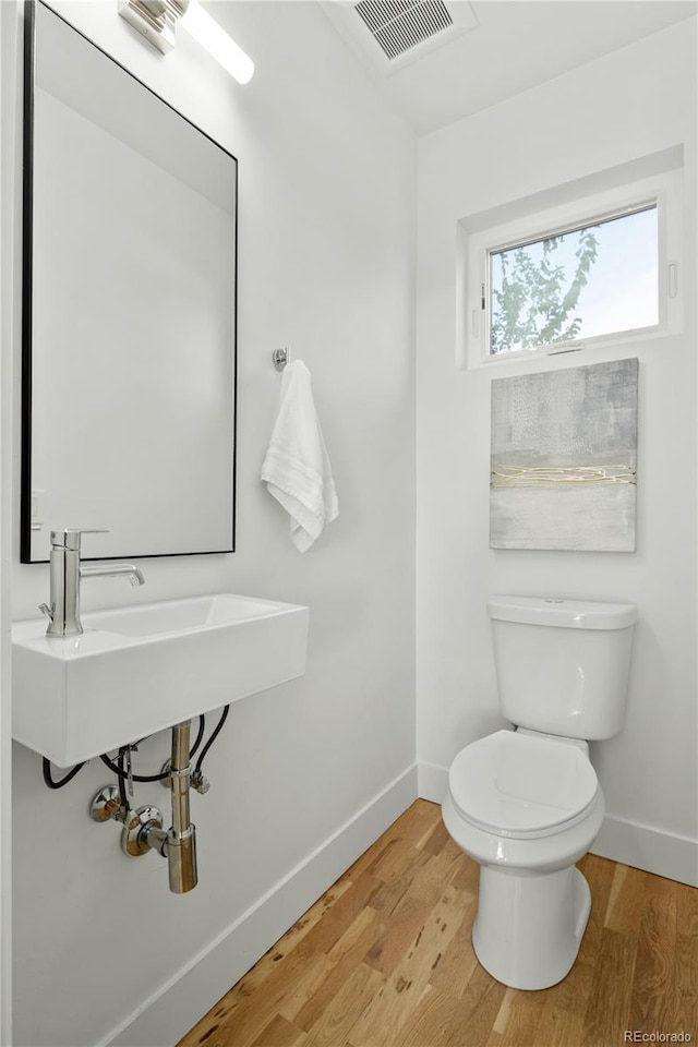 bathroom featuring wood-type flooring, sink, and toilet