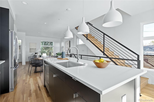 kitchen with pendant lighting, sink, an island with sink, and appliances with stainless steel finishes