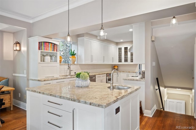 kitchen with decorative backsplash, white cabinetry, a kitchen island with sink, dark hardwood / wood-style floors, and sink