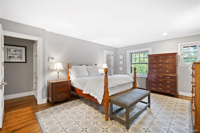 bedroom with ornamental molding and light wood-type flooring