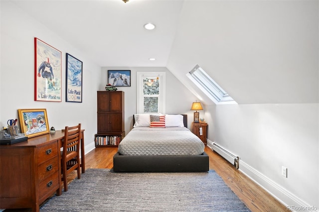 bedroom featuring lofted ceiling with skylight, baseboard heating, and wood-type flooring