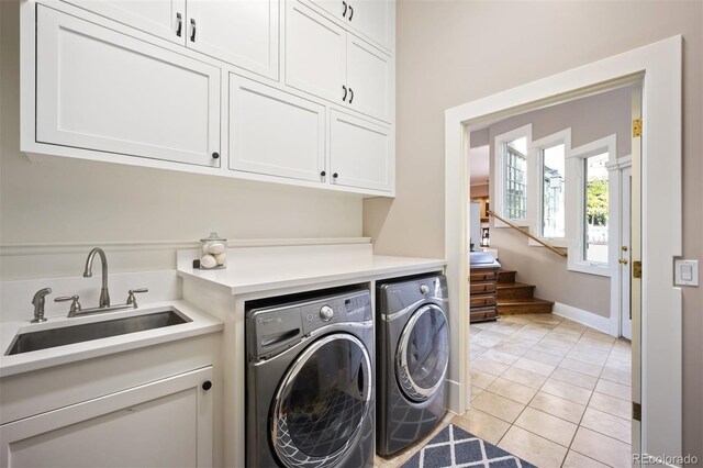 washroom featuring independent washer and dryer, cabinets, sink, and light tile patterned floors