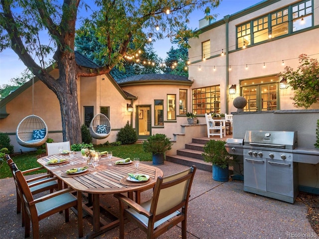 back house at dusk featuring a patio