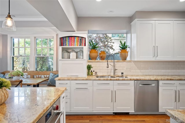 kitchen with white cabinetry, sink, and pendant lighting