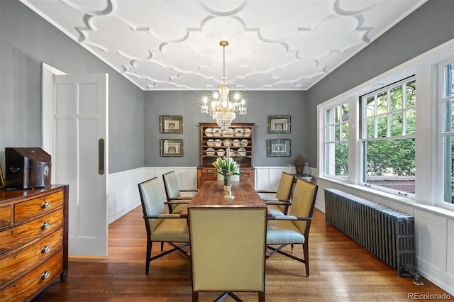 141 N Gilpin St, Denver, CO 80218 - dining room featuring radiator, a chandelier, wood finished floors, and a wainscoted wall