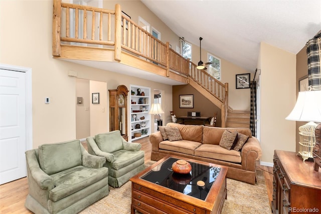 31673 Ponderosa Way, Evergreen, CO 80439 - living area with high vaulted ceiling, stairs, and wood finished floors