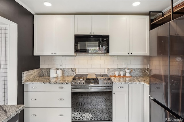 4883 Perry St, Denver, CO 80212 - kitchen featuring black microwave, stainless steel range with gas stovetop, freestanding refrigerator, white cabinets, and recessed lighting