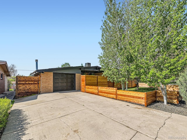 170 W Midway Blvd, Broomfield, CO 80020 - view of side of home with driveway, an attached garage, brick siding, and fence