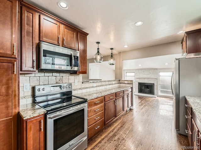 170 W Midway Blvd, Broomfield, CO 80020 - kitchen with appliances with stainless steel finishes, dark wood finished floors, backsplash, light stone countertops, and recessed lighting