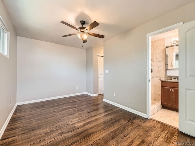 170 W Midway Blvd, Broomfield, CO 80020 - unfurnished bedroom with dark wood-type flooring, baseboards, connected bathroom, and a sink